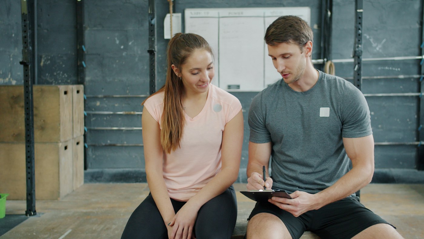 Stock photo of a trainer and client discussing a workout plan
